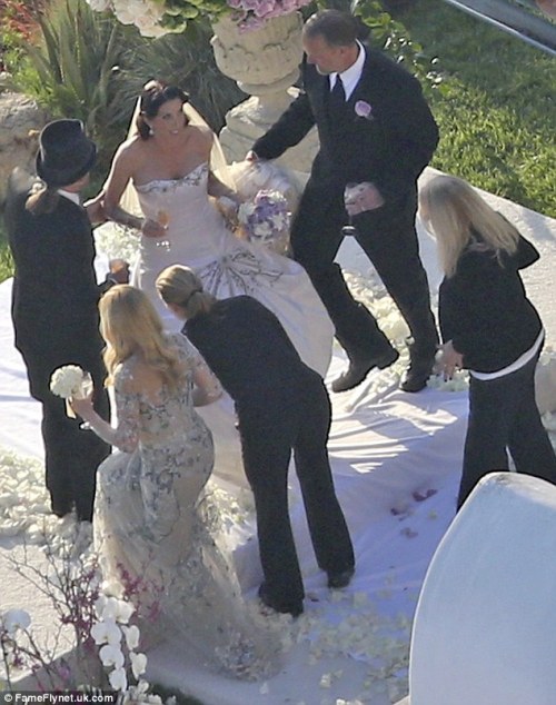 Alexis also wore a dramatic long veil and carried a bouquet of purple and white roses1